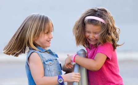 dwie dziewczynki trzymające się poręczy